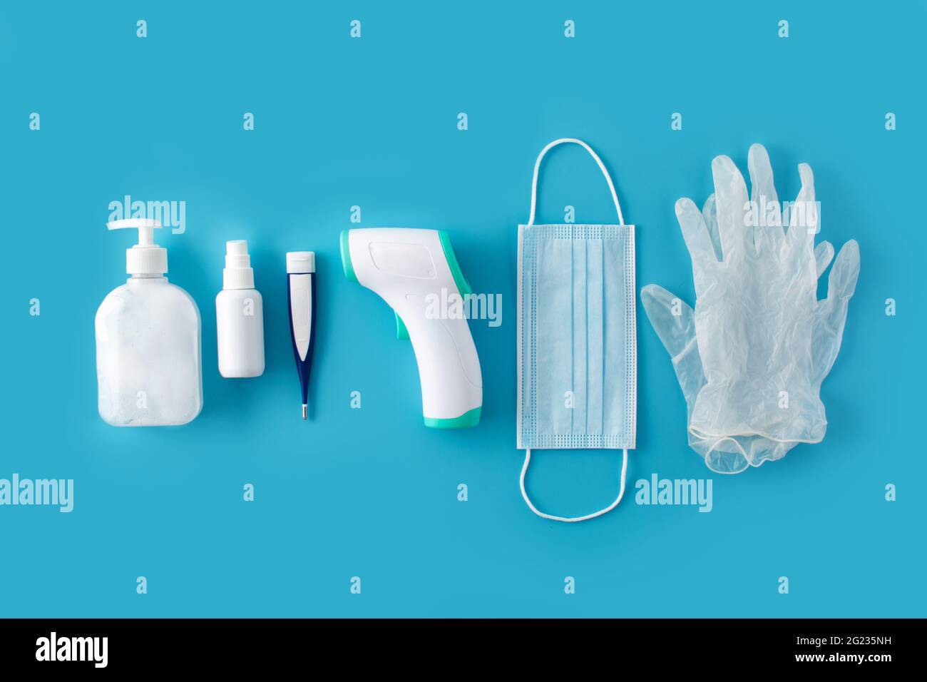 Medical gloves,disinfectant, thermometer, hand sanitizer and surgical mask on blue background Stock Photo