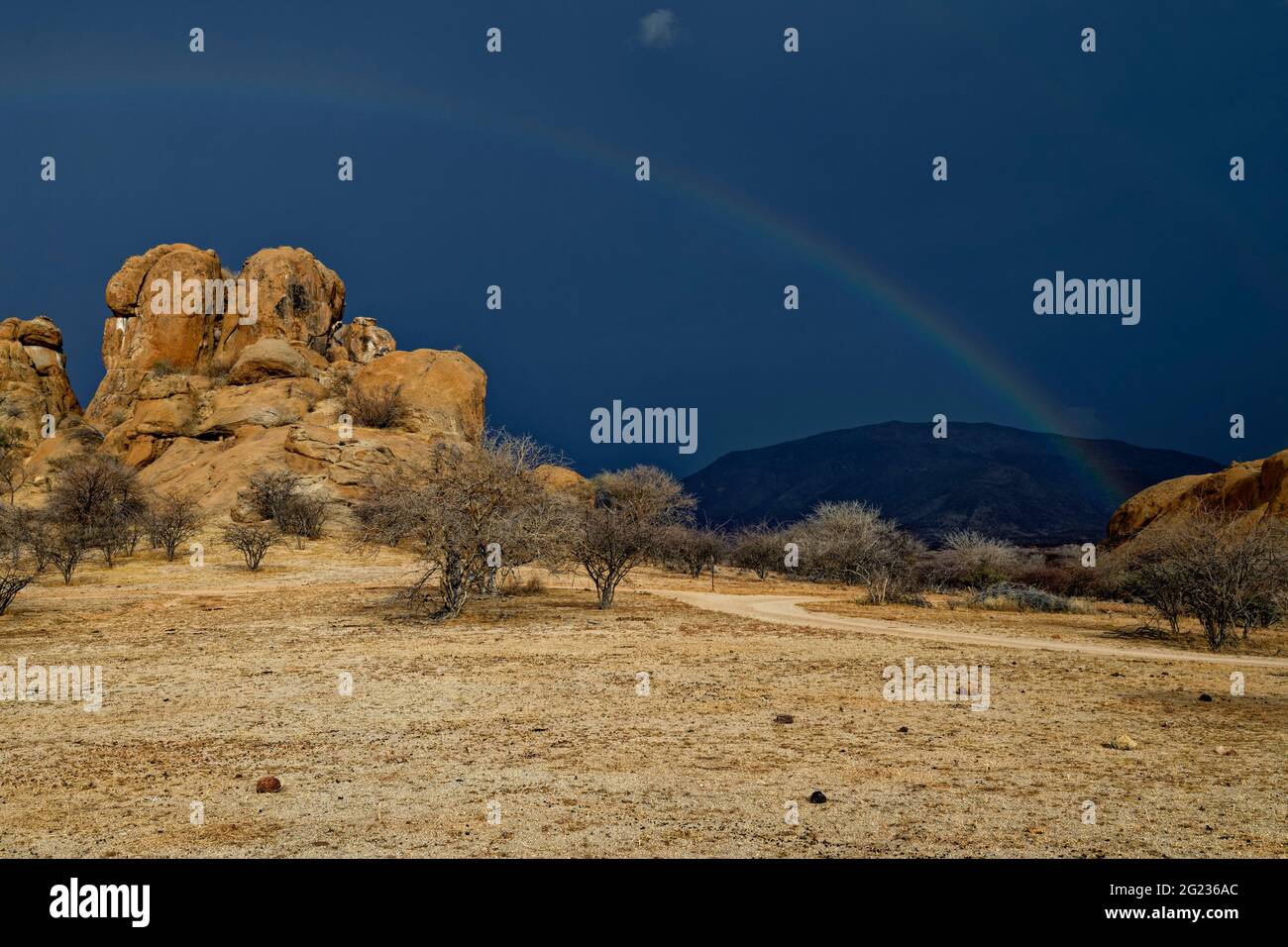 Guest farm Omandumba in the Erongo Mountains: Rainbow over a rock formation (granite), rainy season,  Erongo Region, Namibia Stock Photo