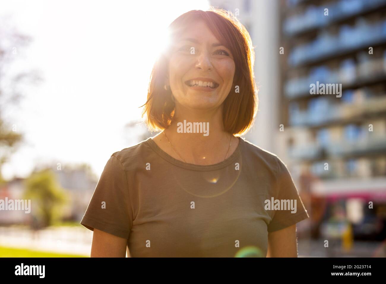 Portrait of smiling redheaded woman in the city Stock Photo