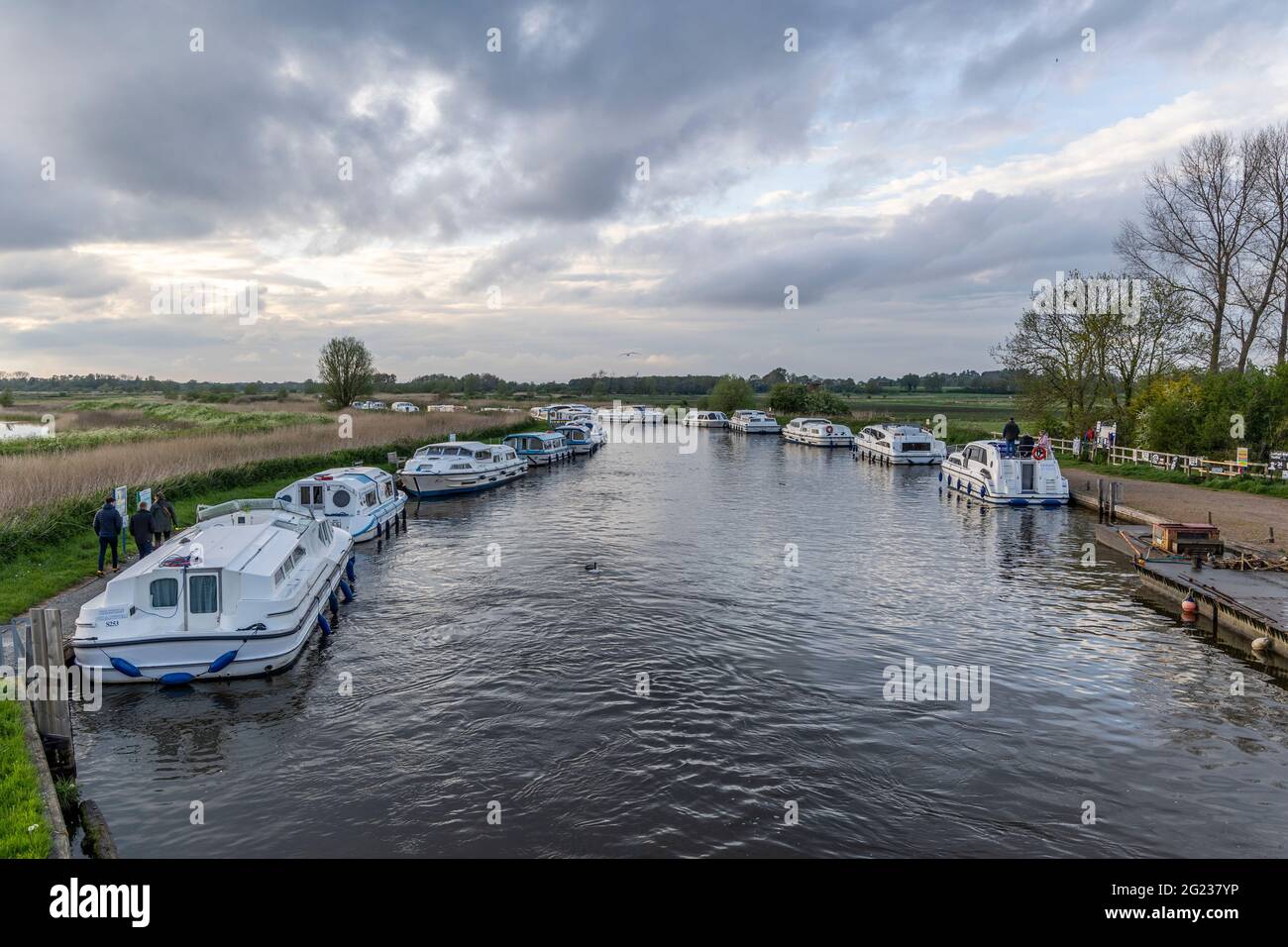 Moored boats and cabin cruises on the River Ant at Ludham bridge, Norfolk Broads Stock Photo