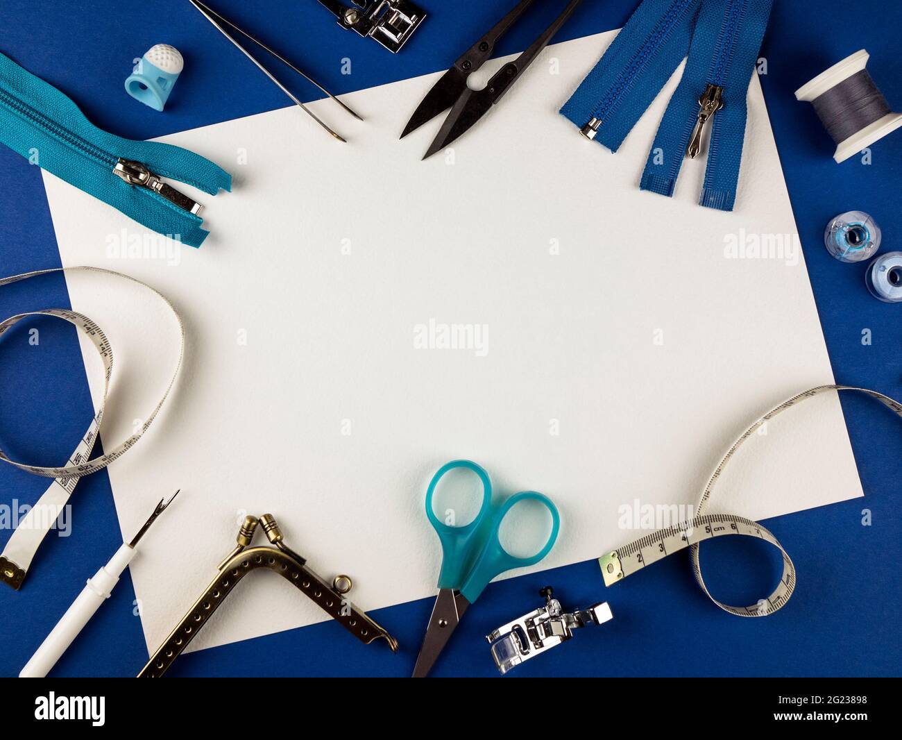 Sewing tools on a blue background with copy space. Scissors, sewing