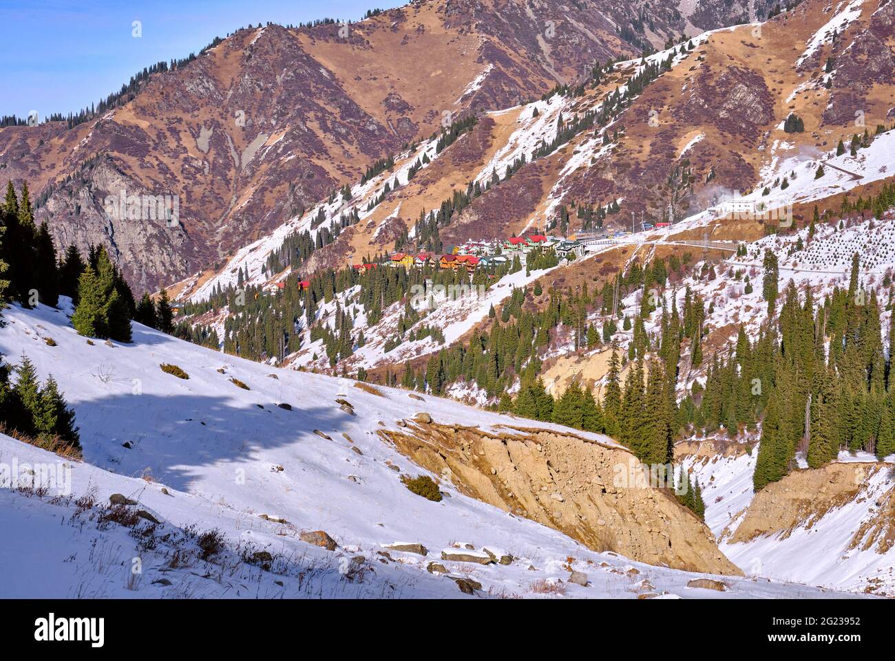 Winter landscape with colored houses, the consequences of a mudflow in the bed of a mountain river; river valley after mudflow in winter season Stock Photo