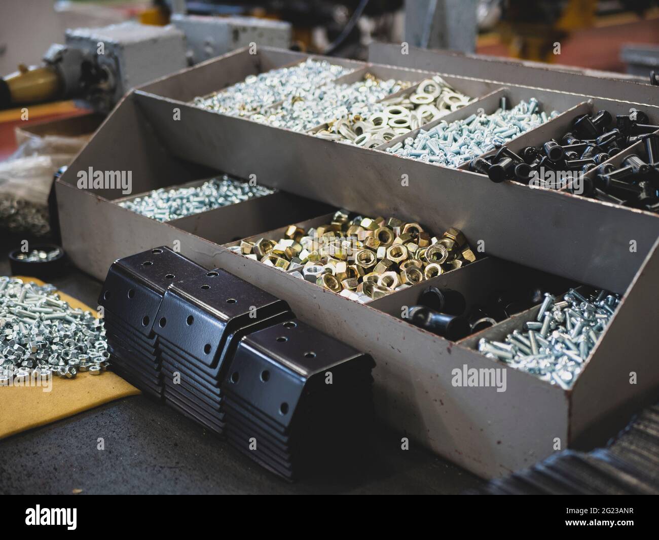 Different types of fasteners on the worker's table. Work place at the assembling shop. Bolts and nuts Stock Photo