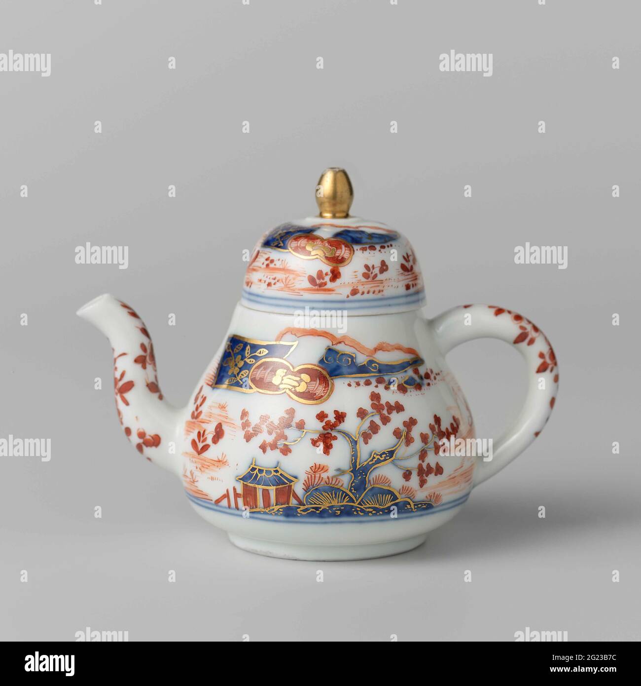 Teapot, painted with an Imari decor. Teapot of painted porcelain. The teapot is painted in the Imii style with trees, houses and a fisherman in a boat. The teapot has been marked. Stock Photo
