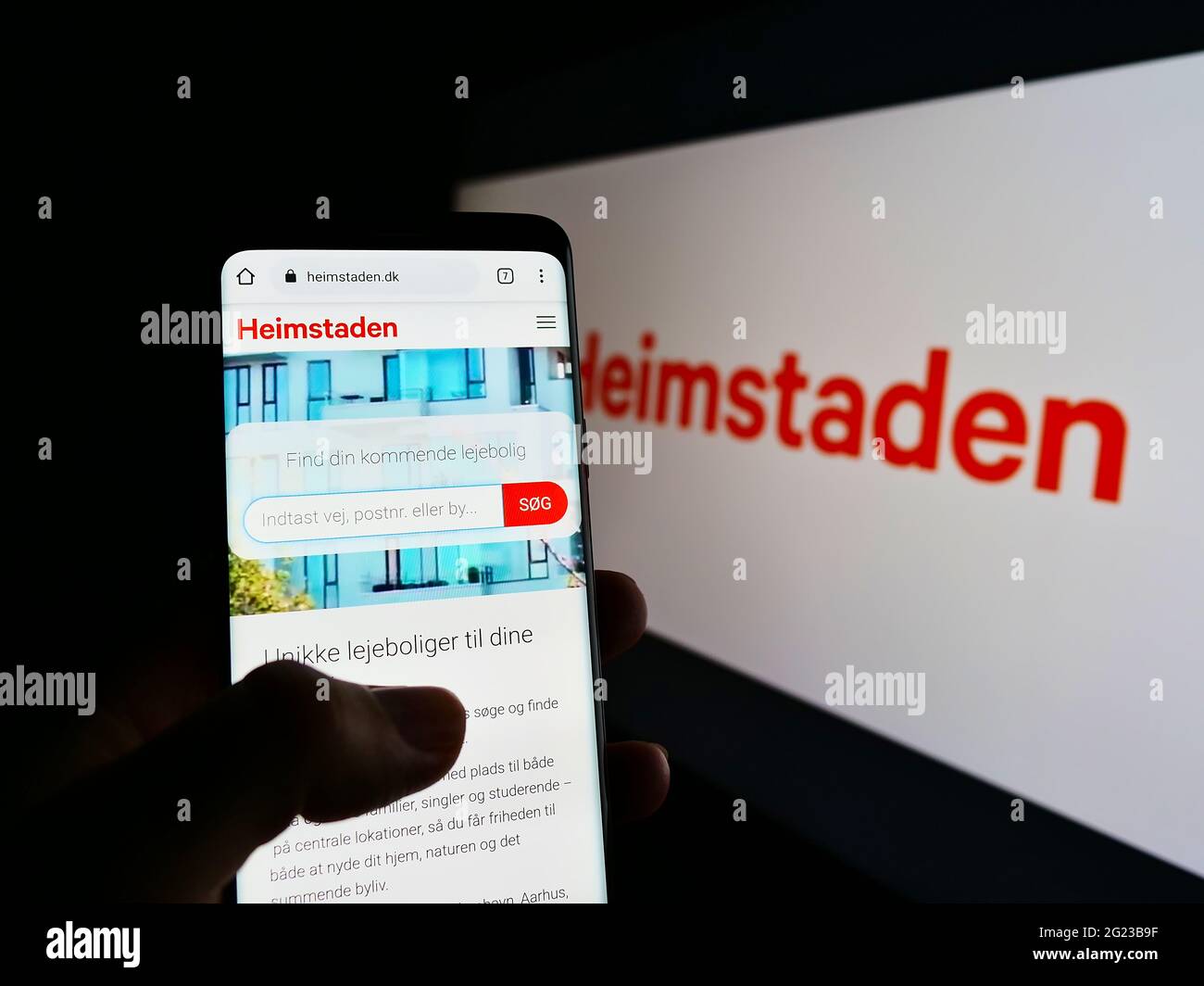 Person holding mobile phone website logo of swedish real estate company