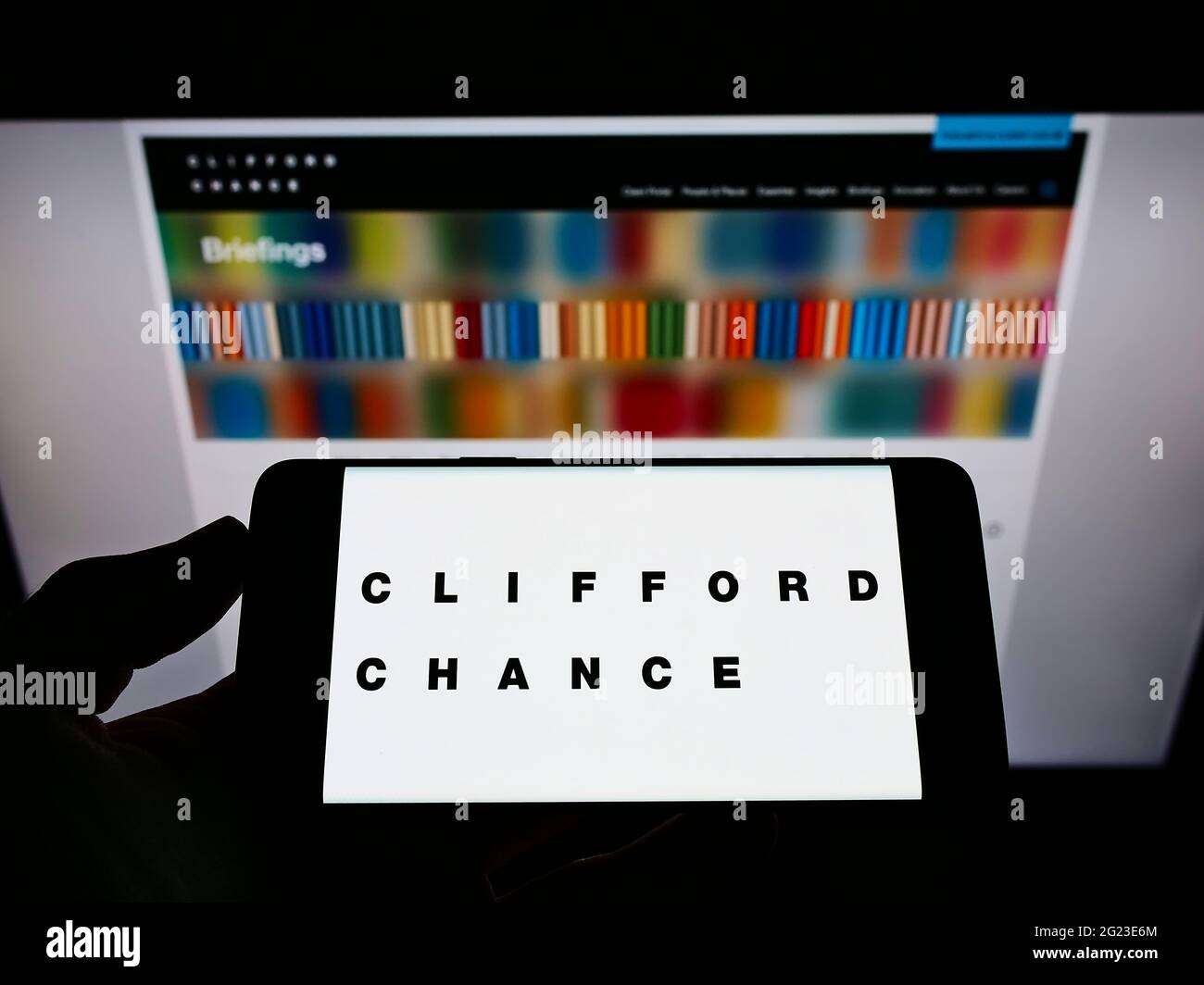 Person Holding Mobile Phone With Logo Of British Law Firm Clifford Chance Llp On Screen In Front Of Business Web Page Focus On Phone Display Stock Photo Alamy