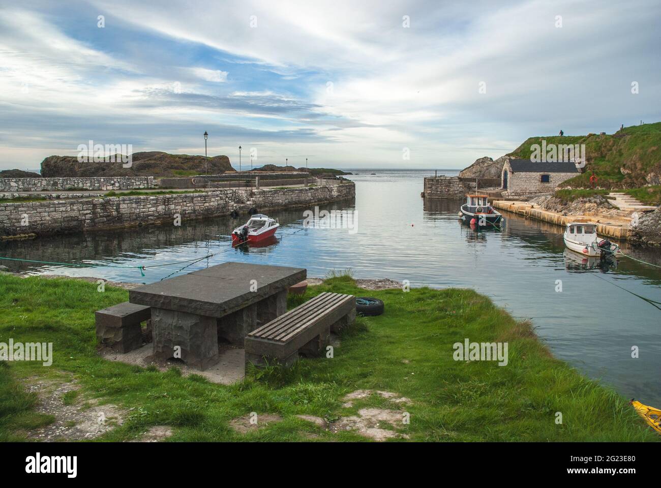 a wooden boat in a body of water in Ballintoy Harbour by Ballycastle in Antrim, Northern Ireland, location for major tv show Stock Photo
