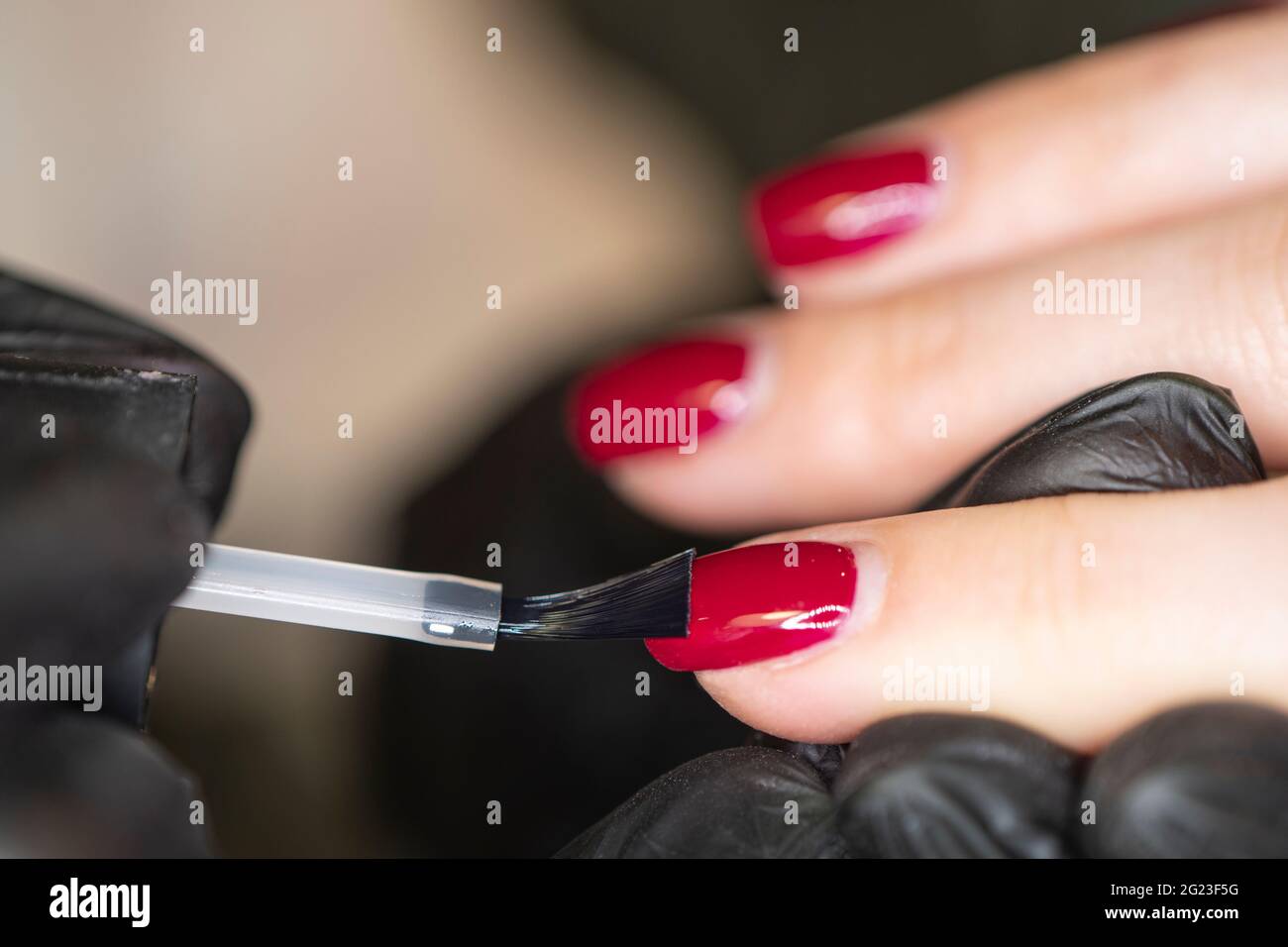 manicurists paints her nails painted. Woman manicurist master in gloves