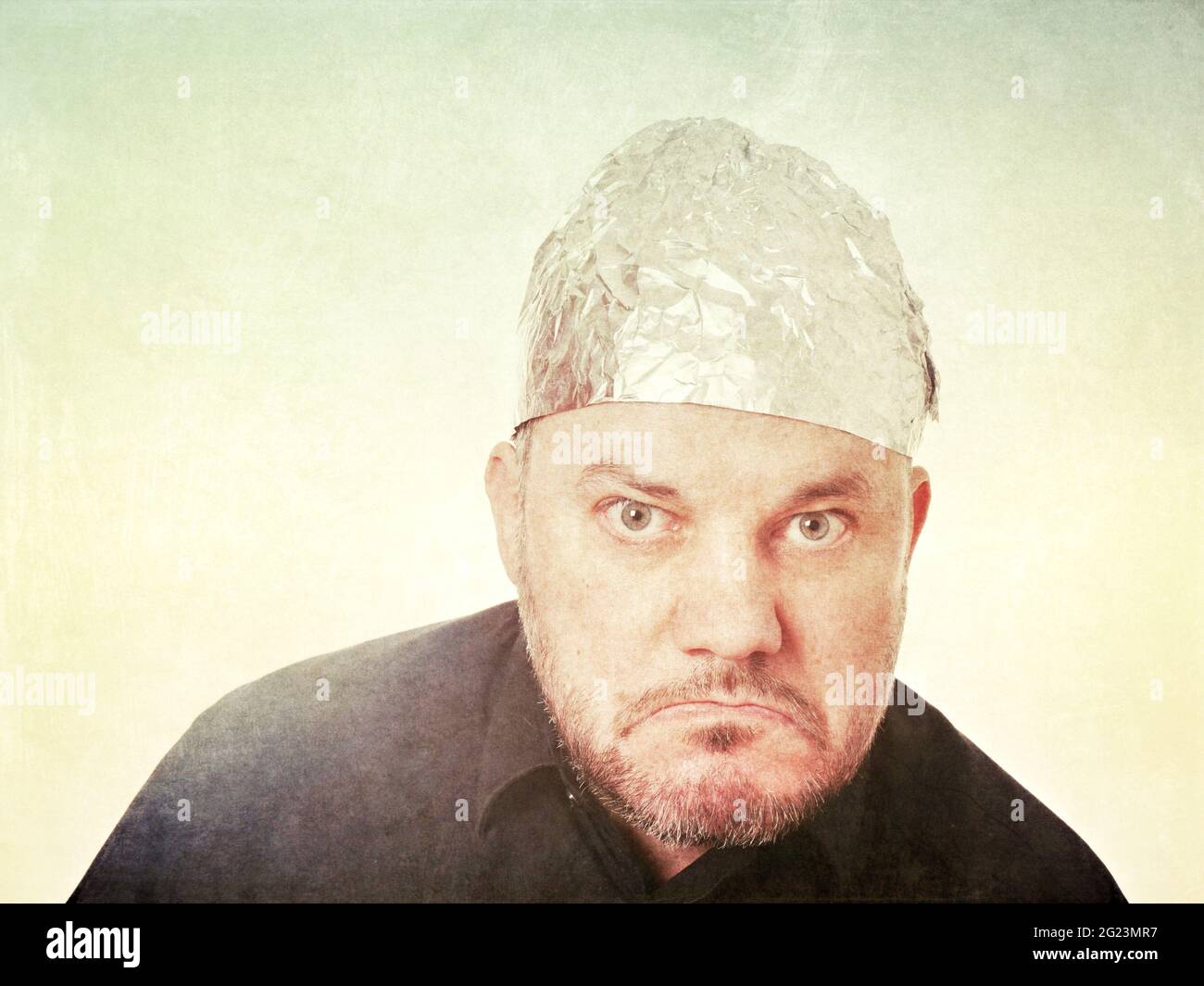 grumpy paranoid man wearing tin foil hat Stock Photo
