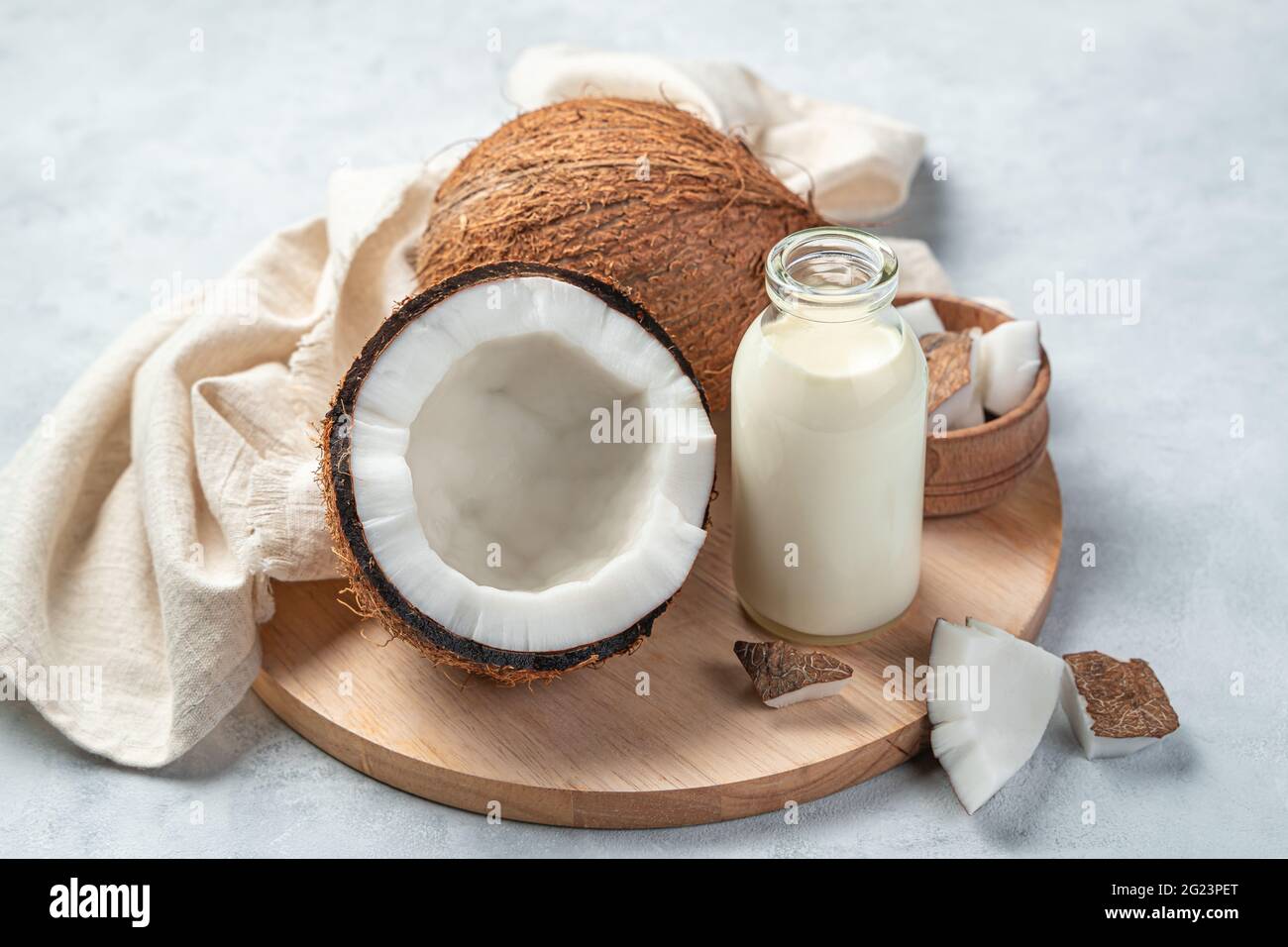 Coconut milk in a bottle and coconut on a gray background. Cow's milk