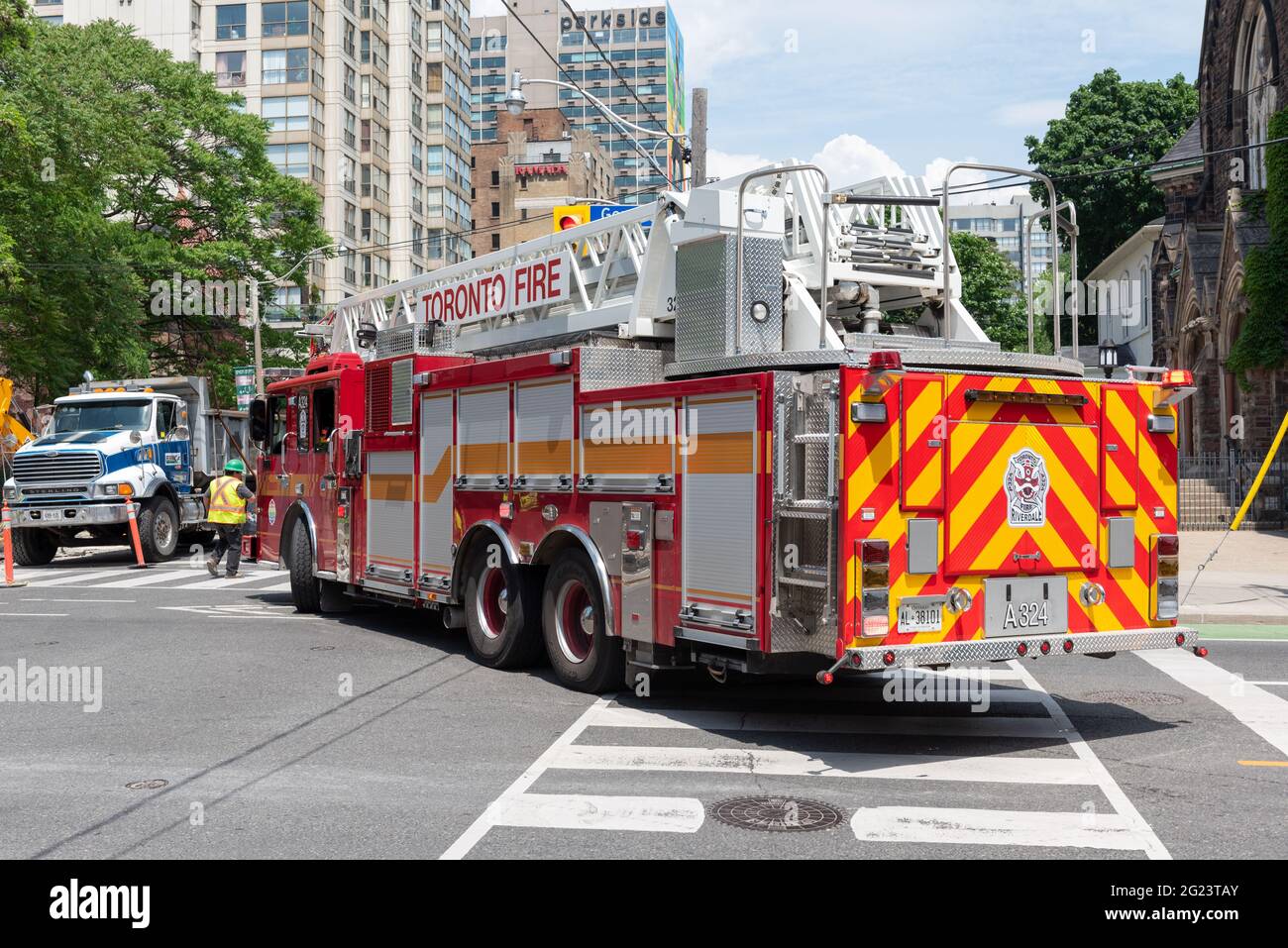 Fire truck or fire engine turning in Jarvis Street where a construction site interrupts its speedy run to a fire alarm in the city, Toronto, Canada Stock Photo