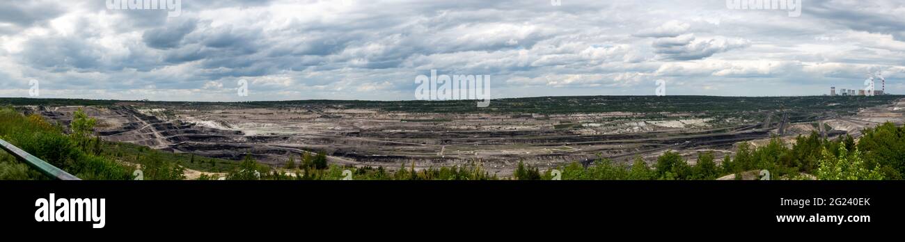 Panoramic view of a lignite-fired power plant against the background of an opencast coal mine. Photo taken in daylight. Lots of little clouds in the s Stock Photo