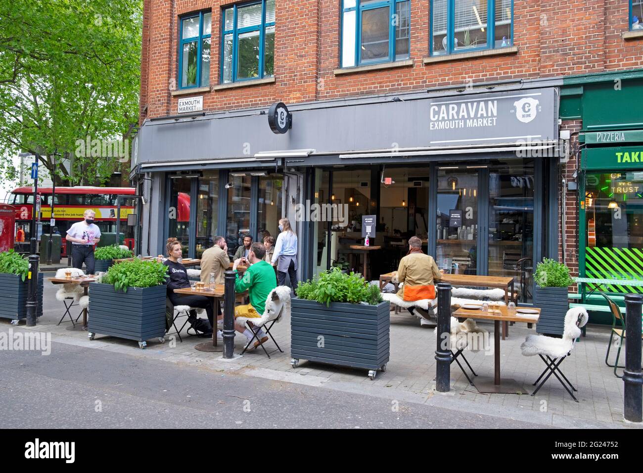 People eating and drinking outside Caravan restaurant at Exmouth Market street in Clerkenwell Borough of Islington London EC1 England UK  KATHY DEWITT Stock Photo