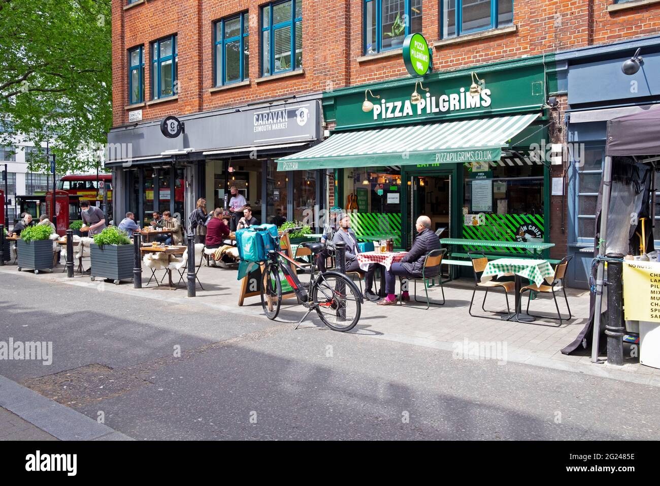 People sitting at tables at Pizza Pilgrims  and Caravan restaurant Exmouth Market street in Clerkenwell Islington London EC1 England UK  KATHY DEWITT Stock Photo