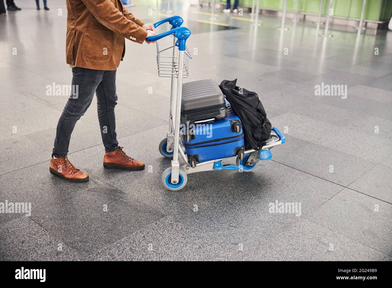 Male passenger pushing baggage cart at airport Stock Photo Alamy