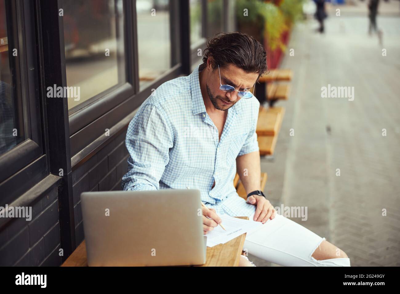 Busy freelancer making notes during online conference Stock Photo
