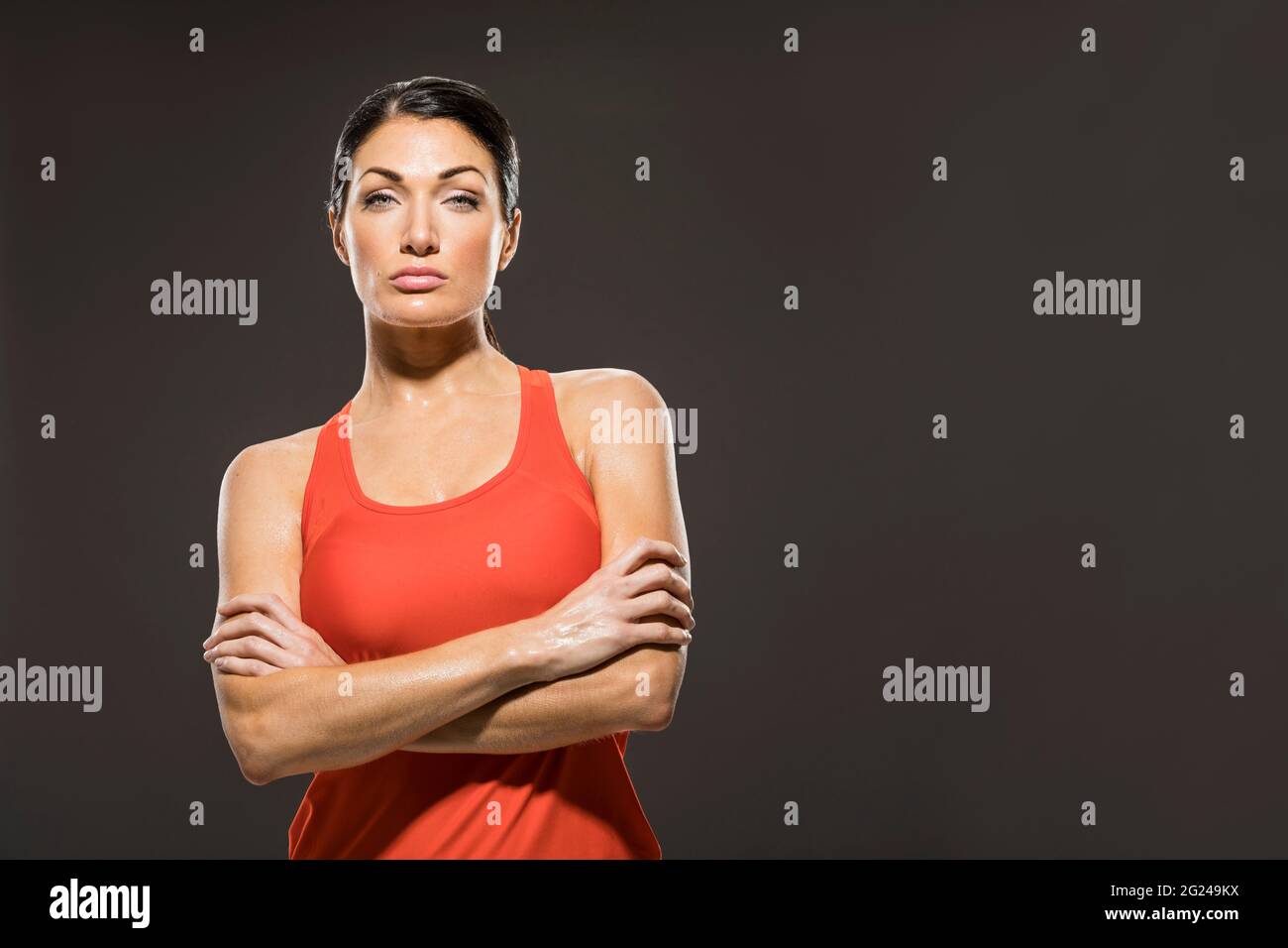 Studio portrait of athletic woman in red sleeveless top Stock Photo