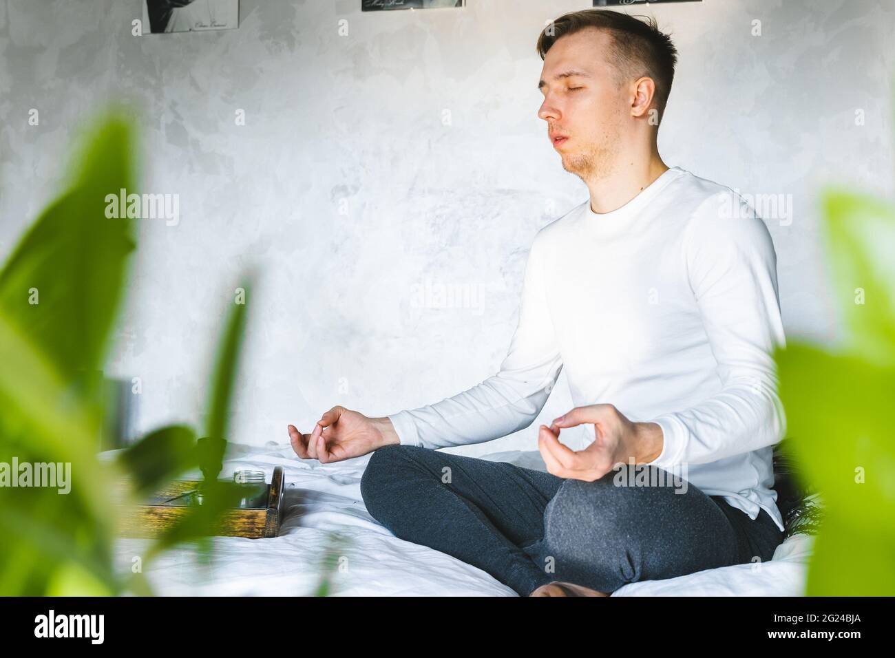 Man Sitting On Bed At Home Meditating after waking up in morning ...