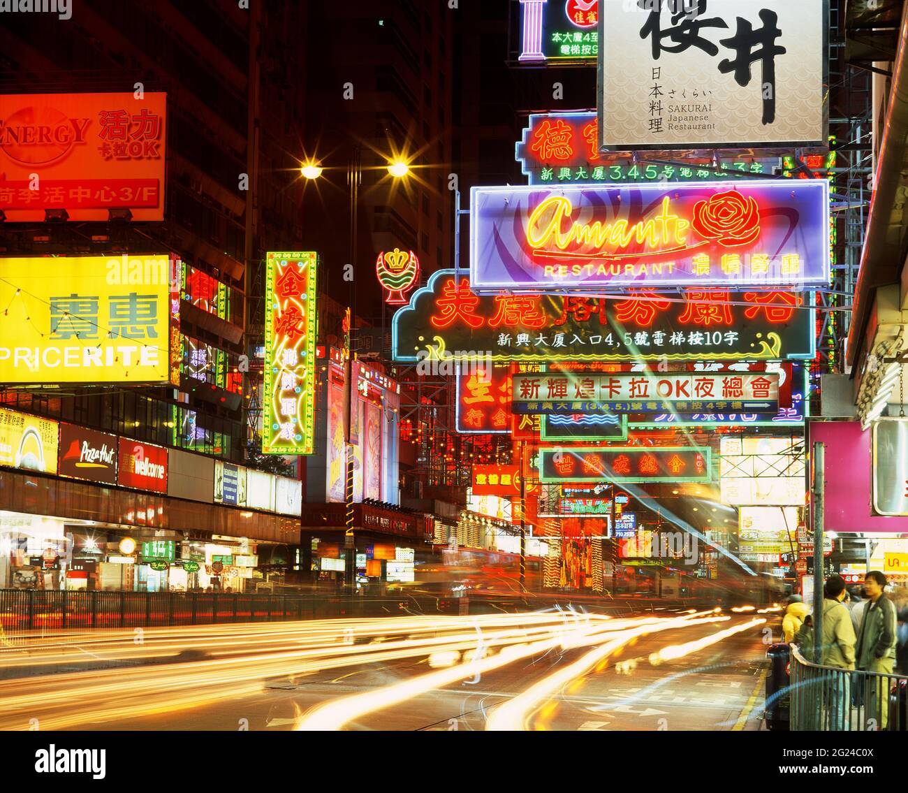 China, Hong Kong, Neon lights and signs on busy city street at night ...
