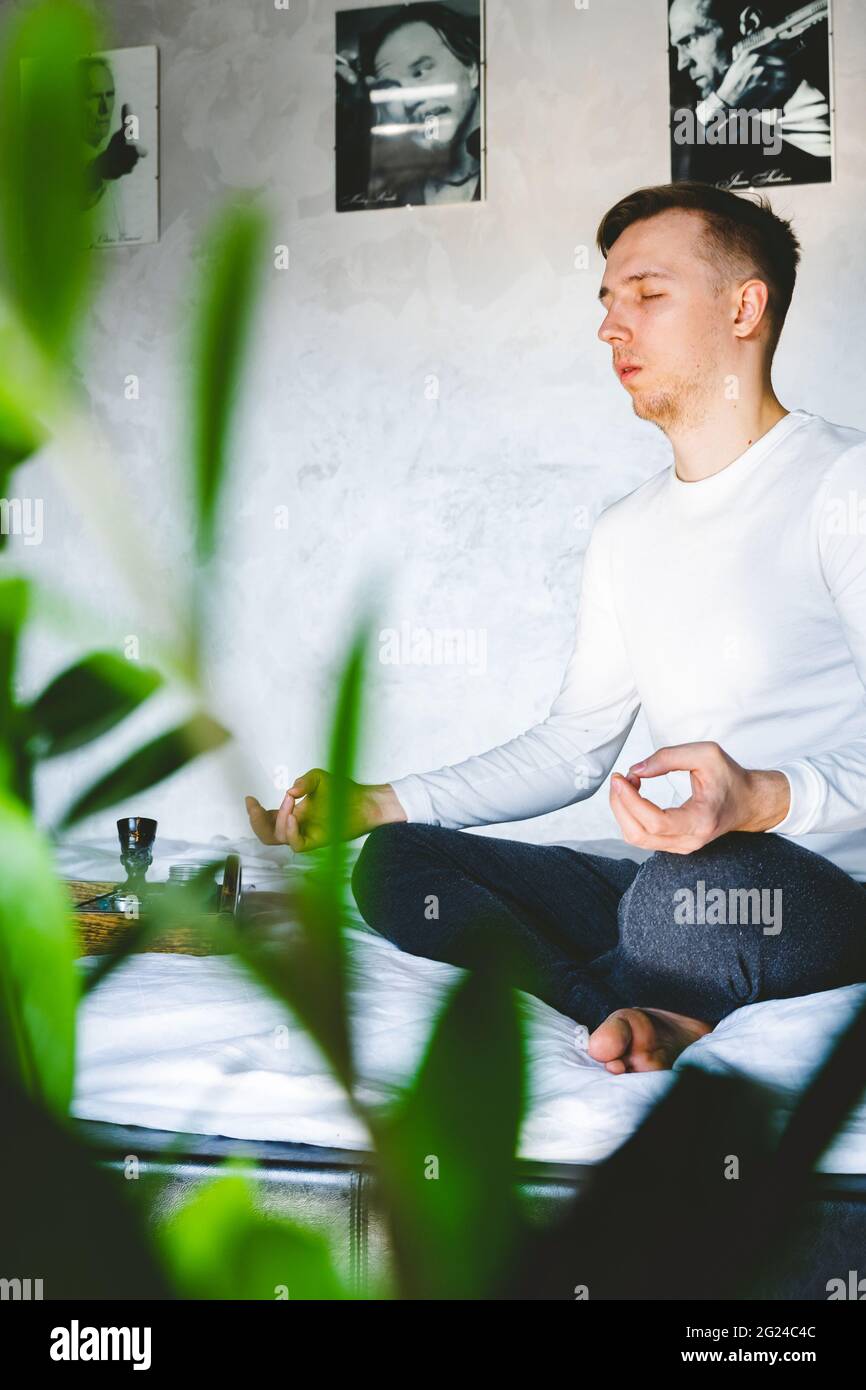 Man Sitting On Bed At Home Meditating after waking up in morning ...