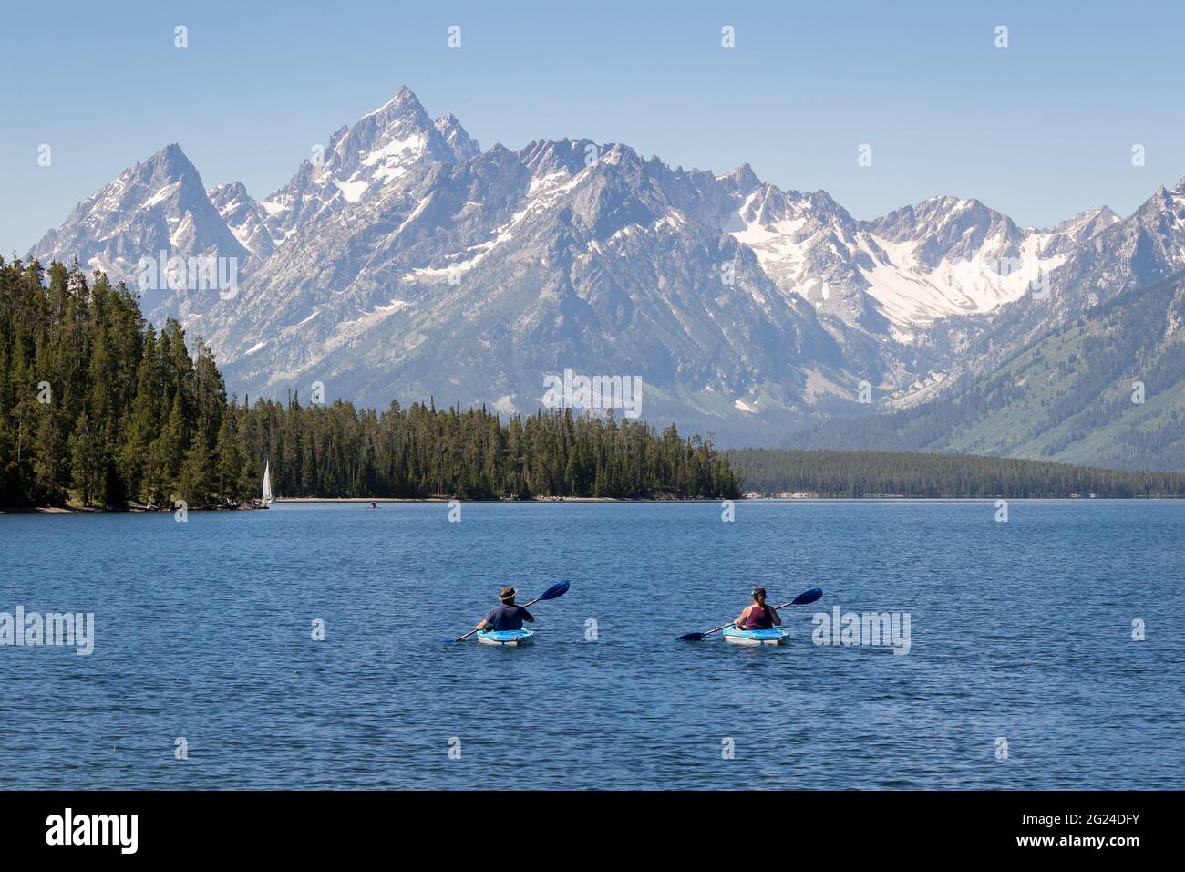two people kayaking in Jackson Lake at Grand Teton National Park. Mountain range in background Stock Photo