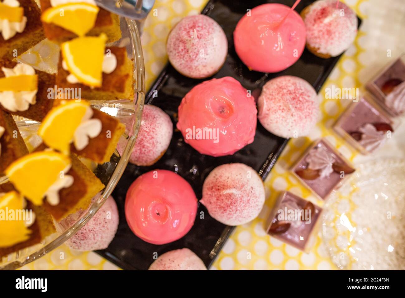 apples in pink caramel on a black plate on a buffet table Stock Photo