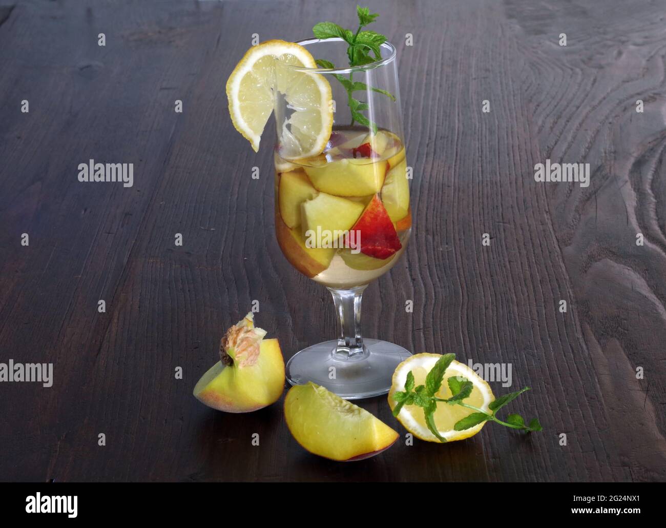 Peach in white wine with lemon and mint leaves Stock Photo