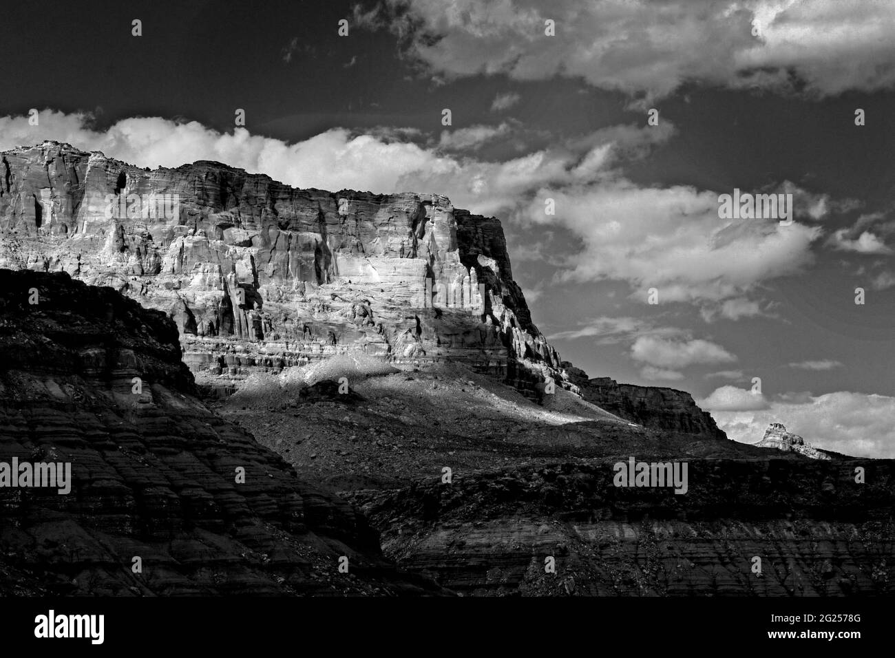 Crisp, clean black and white image of clouds, a canyon, a steep rock cliff and a flat mesa. Sharp contrasts between blacks and whites. Beautiful image Stock Photo