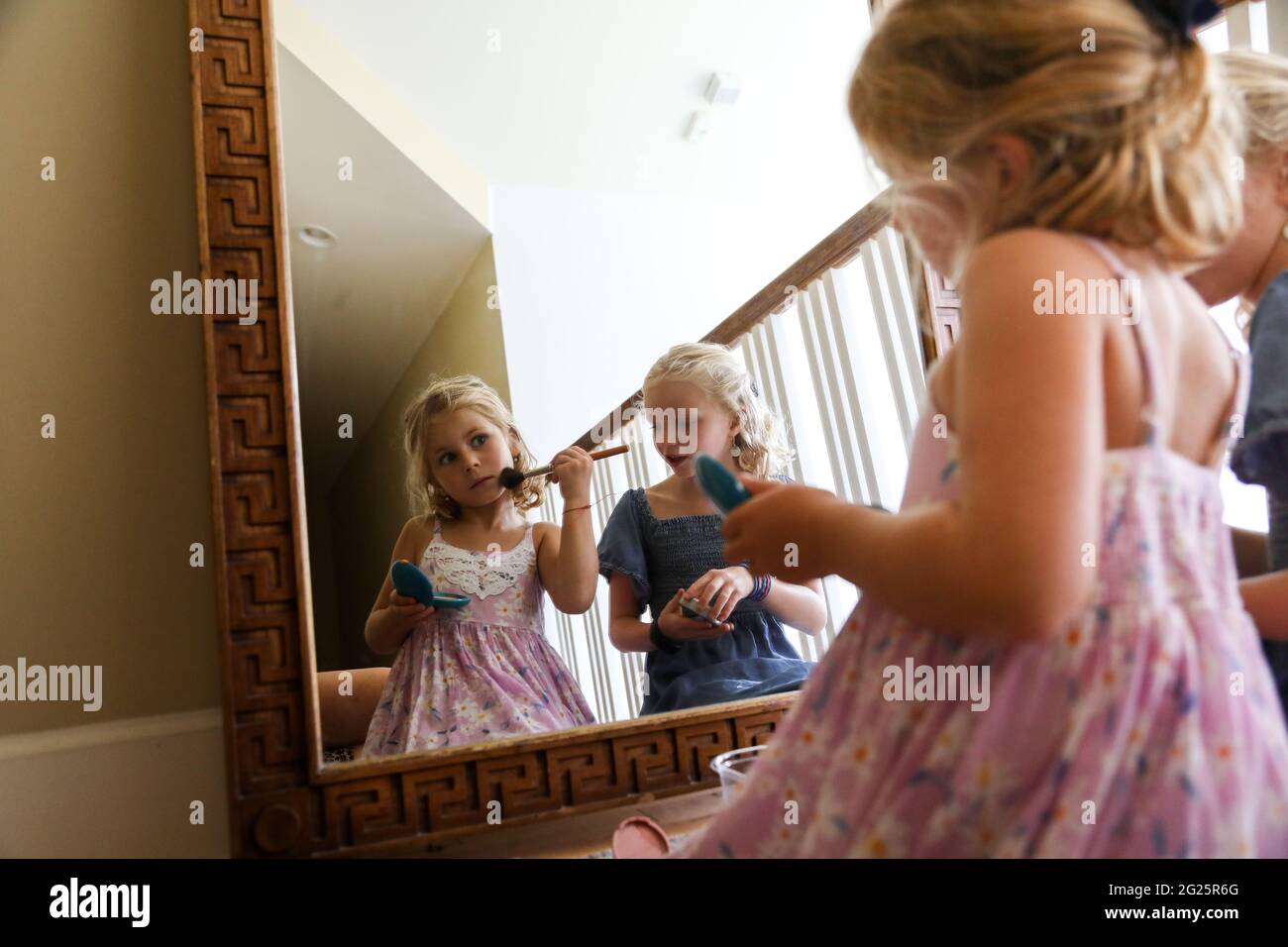 little girl look at herself in mirror putting on blush Stock Photo - Alamy