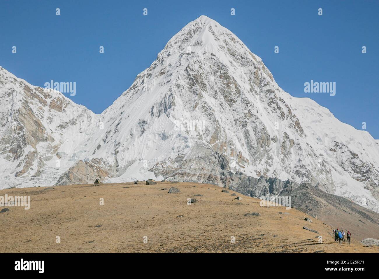 Scale: Pumori and a climbing team headed towards Everest Basecamp Stock Photo