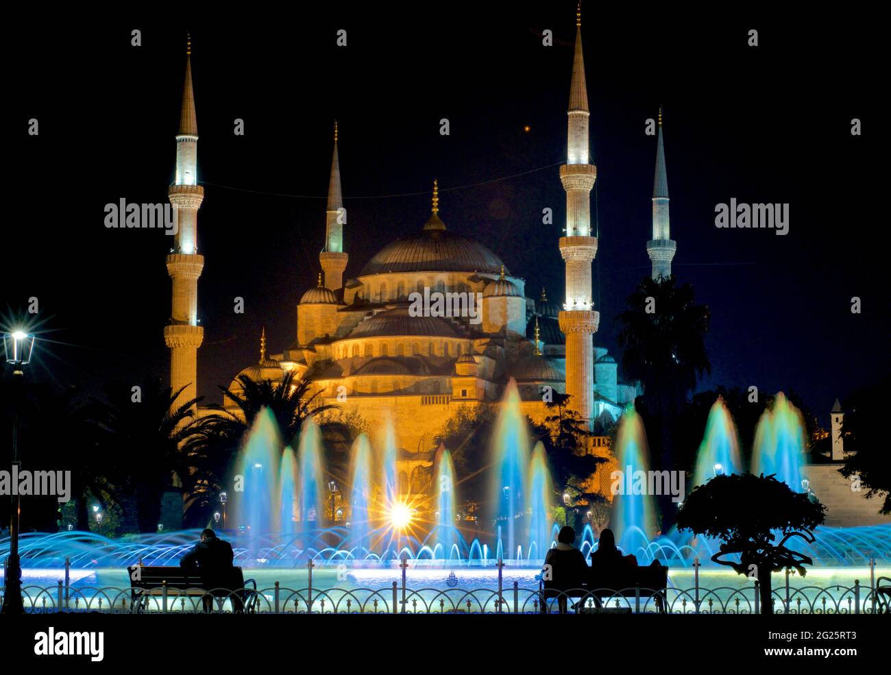Sultan Ahmed Mosque (Turkish: Sultan Ahmet Camii), also known as the Blue Mosque. An Ottoman-era Friday mosque located in Istanbul, Turkey. Illuminated at night; colourfully-lit Sultan Ahmad Maydan water fountain Stock Photo