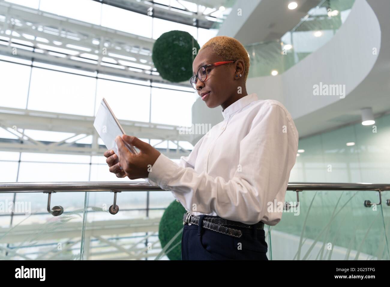 African American analyst browsing tablet near railing Stock Photo