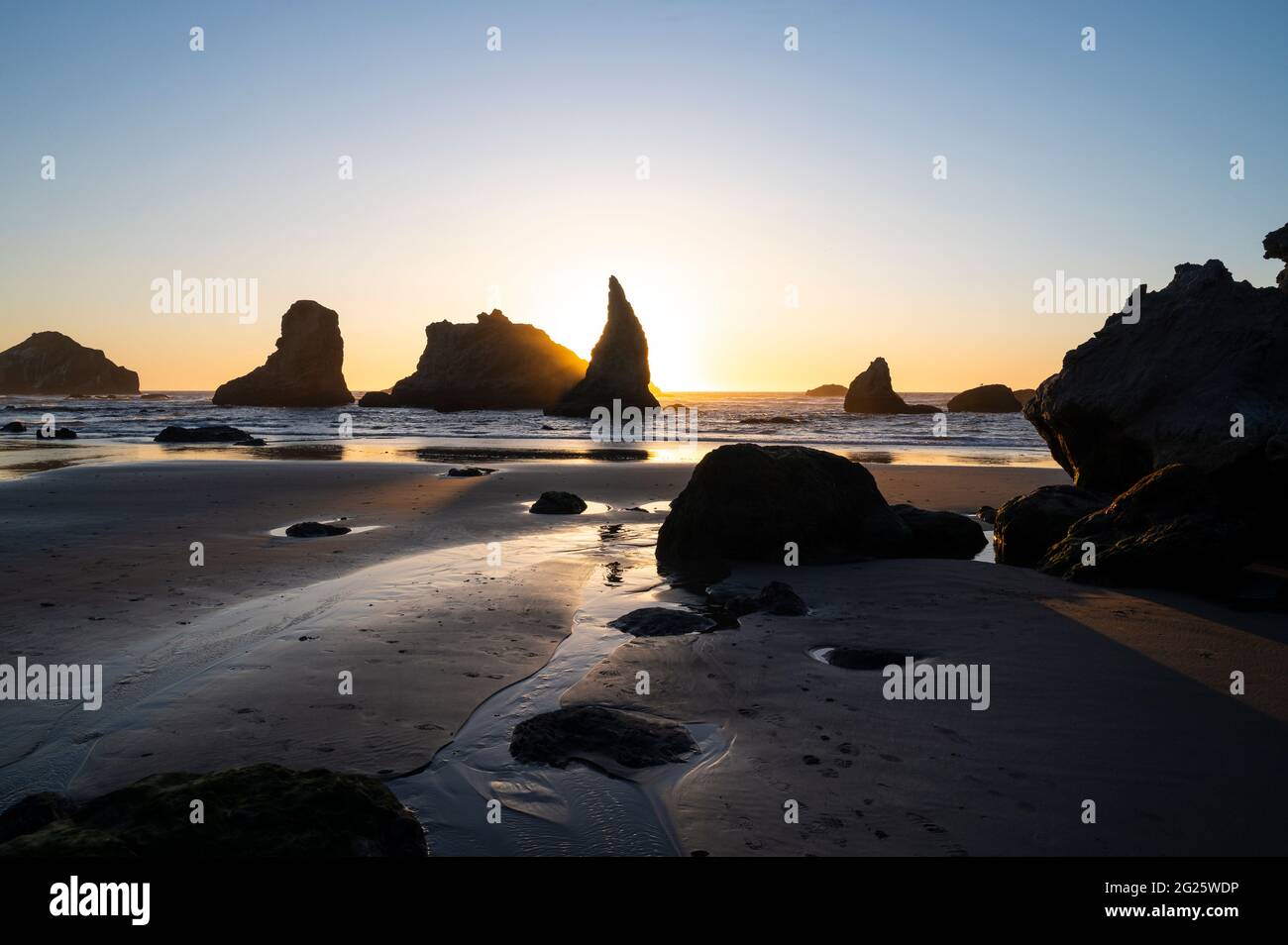 Sun Setting Behind Sea Stacks On The Oregon Coast Stock Photo - Alamy