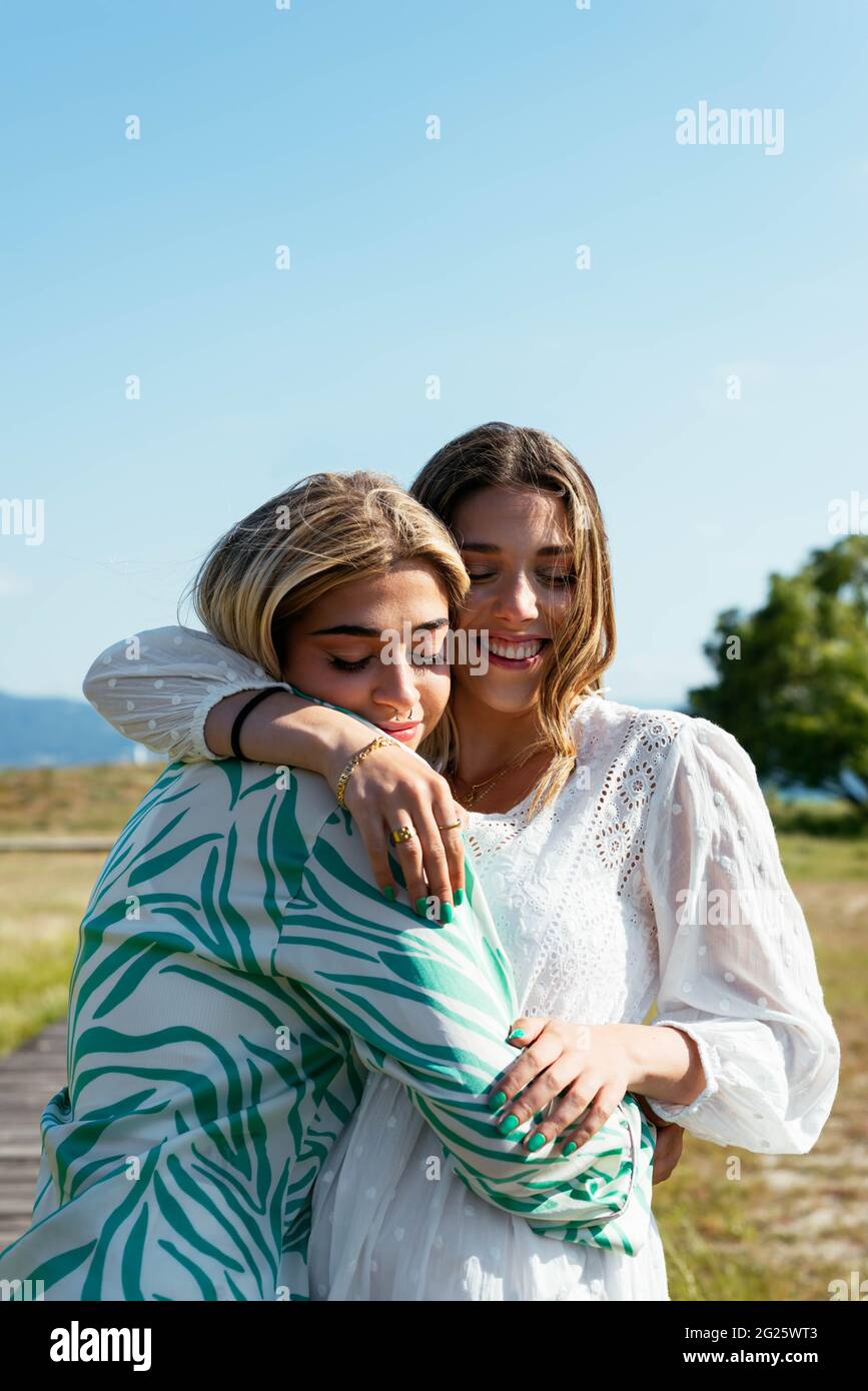 Smiling female best friends hugging each other Stock Photo