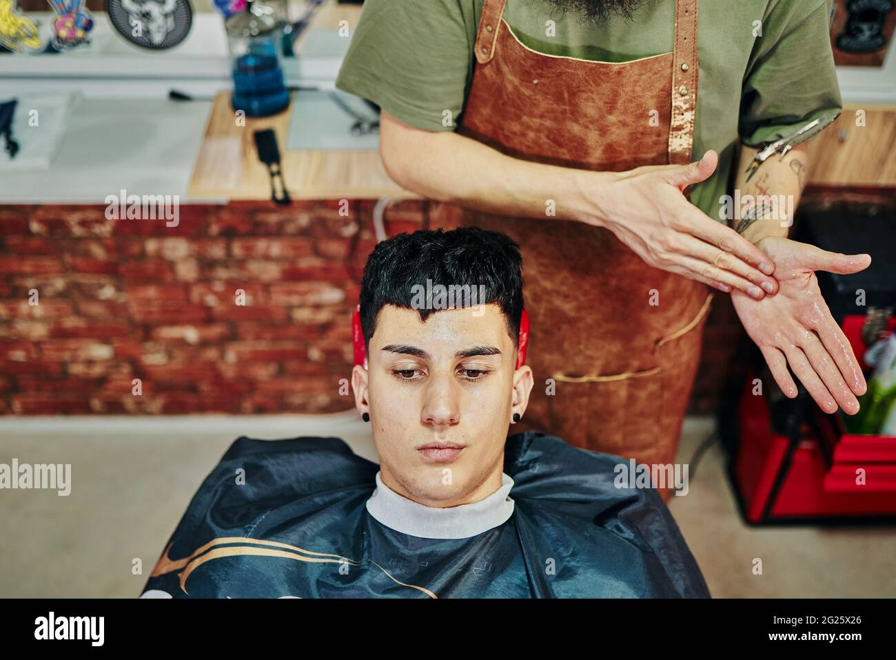 A young boy in the barber shop waiting to receive a facial massage