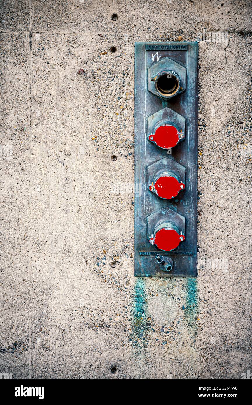 fire hose connectors on building wall Stock Photo