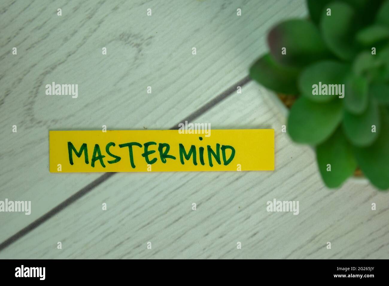 Mastermind write on sticky notes isolated on Wooden Table. Stock Photo