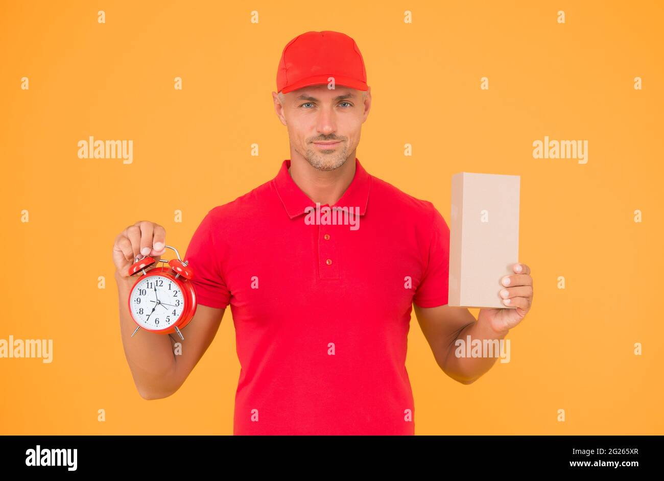 Take your shopping time. Delivery man hold clock and box yellow background. Online shopping. Cyber Monday. Sales shopping. Shopping and fast delivery Stock Photo
