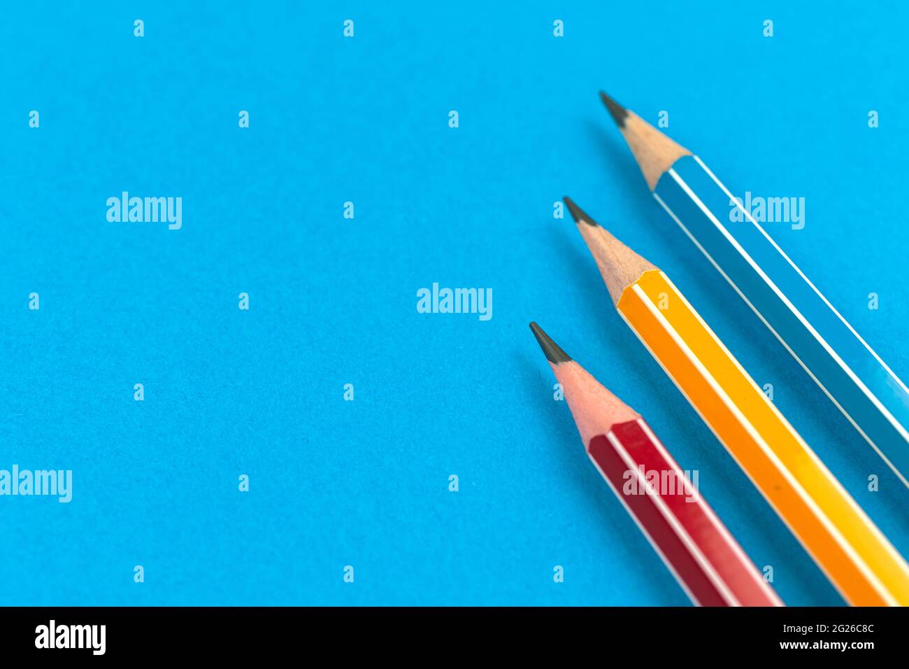 Preparing for the first days of school with simple lead pencils on flat lay blue background, copy space photo Stock Photo