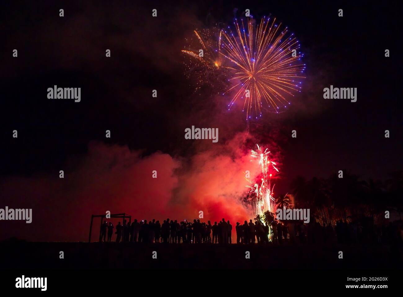 A Crowd Of People Are Watching A Colorful Fireworks Celebration Display Stock Photo