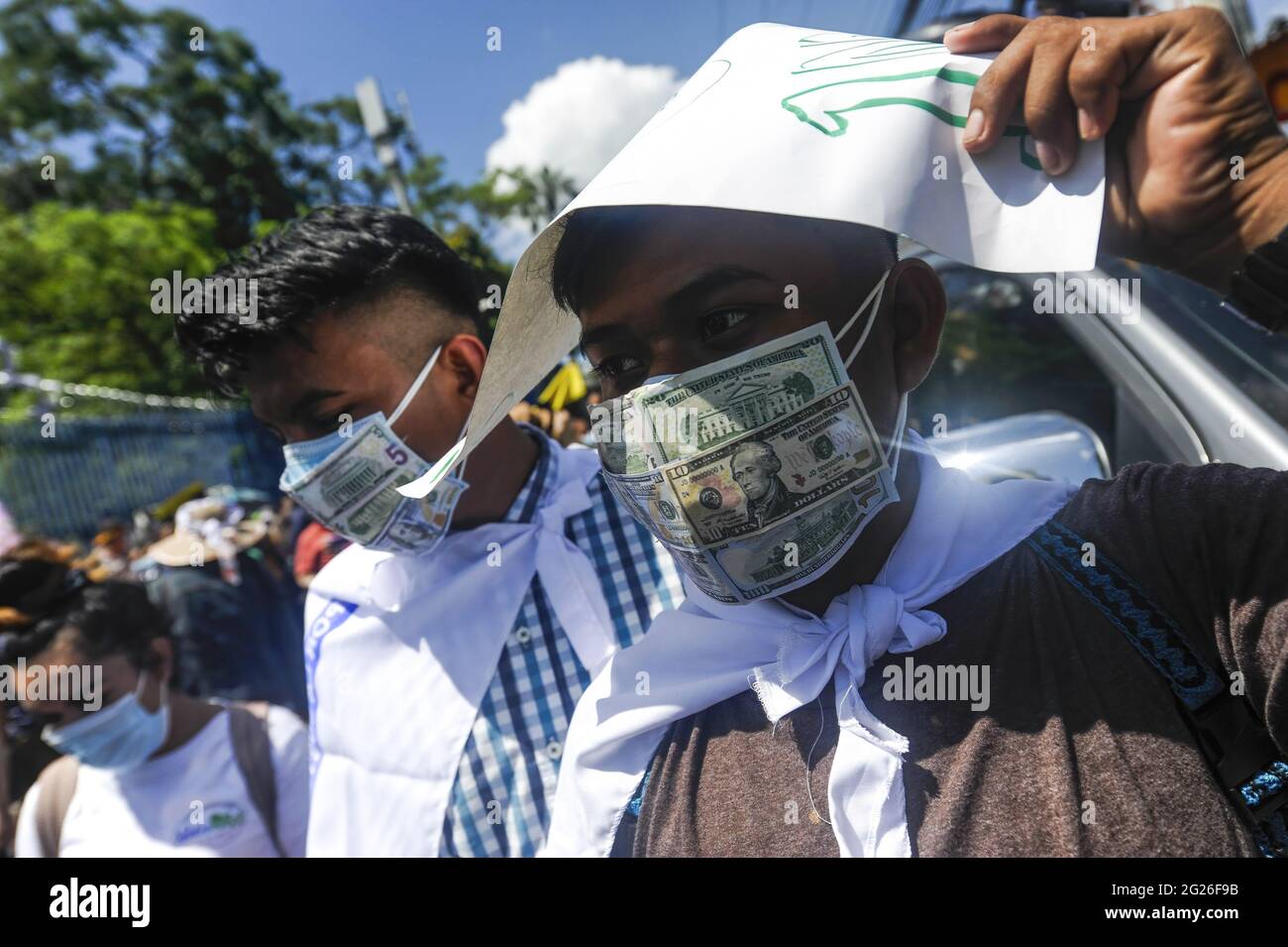 San Salvador, El Salvador. 08th June, 2021. Demonstrators wear protective masks displaying fake US Dollar bills during the demonstration. Members of churches and social movements took to the streets to protest for the environment, the Salvadoran Congress archived hundreds of law protects including several proposal for the environment, including water as a human right. Credit: SOPA Images Limited/Alamy Live News Stock Photo