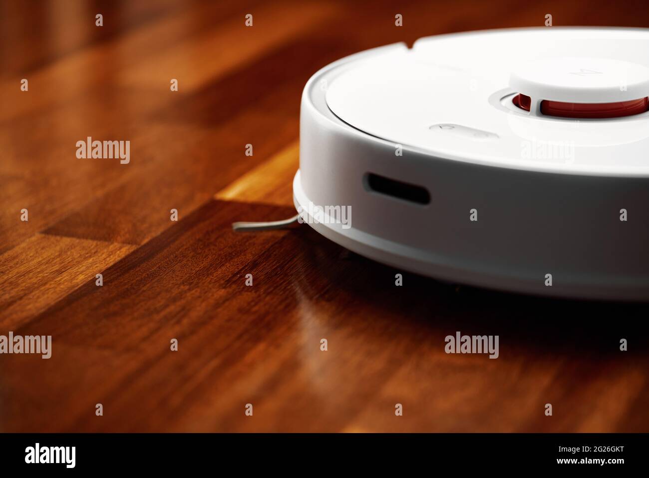 Smart Robot Vacuum Cleaner on wood floor. Robot vacuum cleaner performs