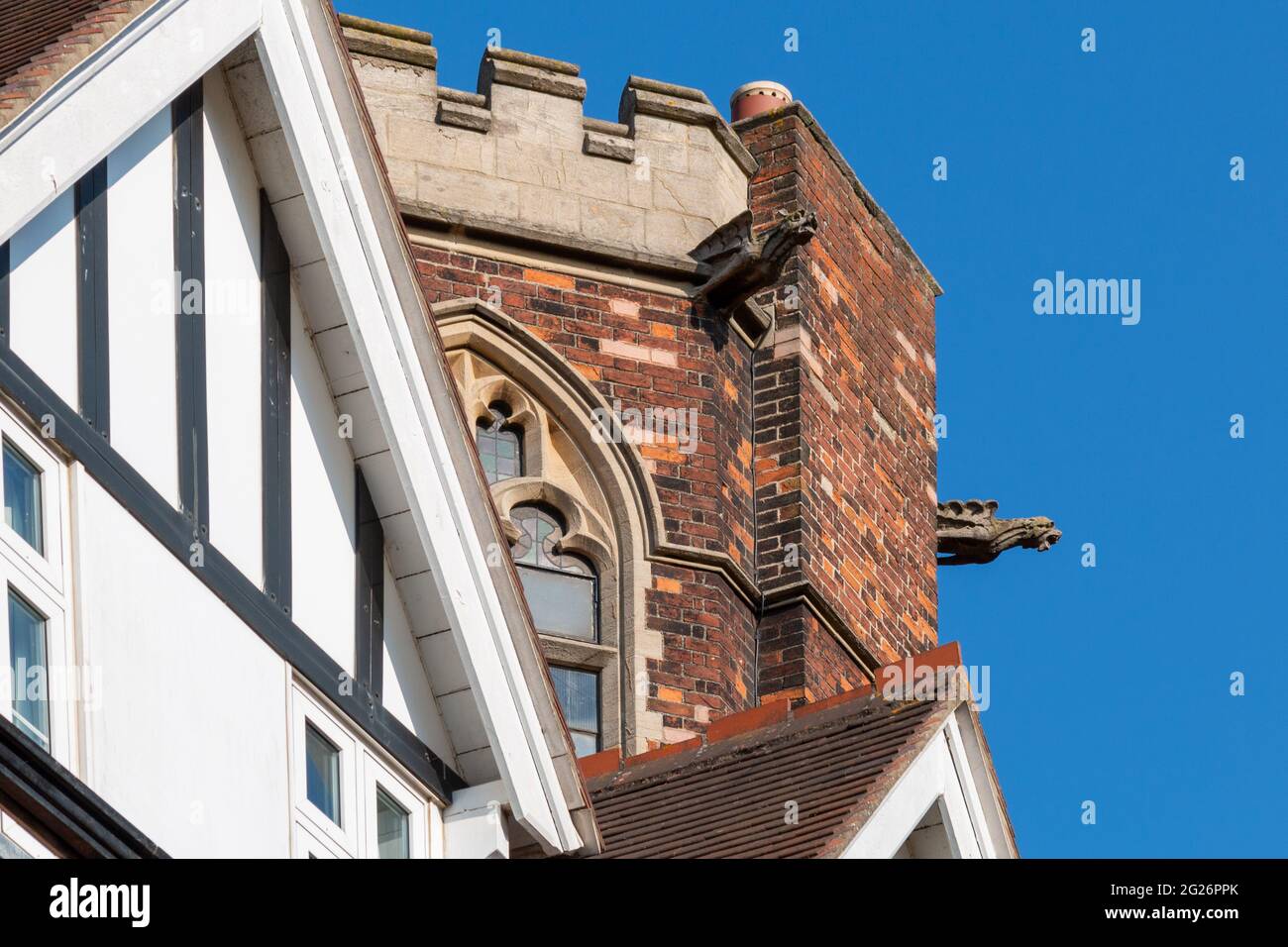 A gargoyle protudes from the castellated tower of Homerton College, Cambridge, UK. Stock Photo