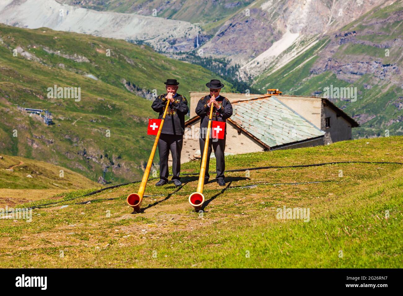 ZERMATT, SWITZERLAND - JULY 16, 2019: Swiss alphorn blowers are playing music near the Matterhorn mountain in the Alps, located between Switzerland an Stock Photo