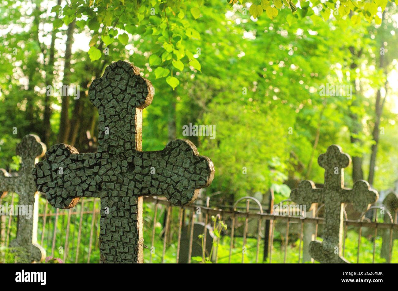 one cross on the grave and several crosses further on the cemetery Stock Photo