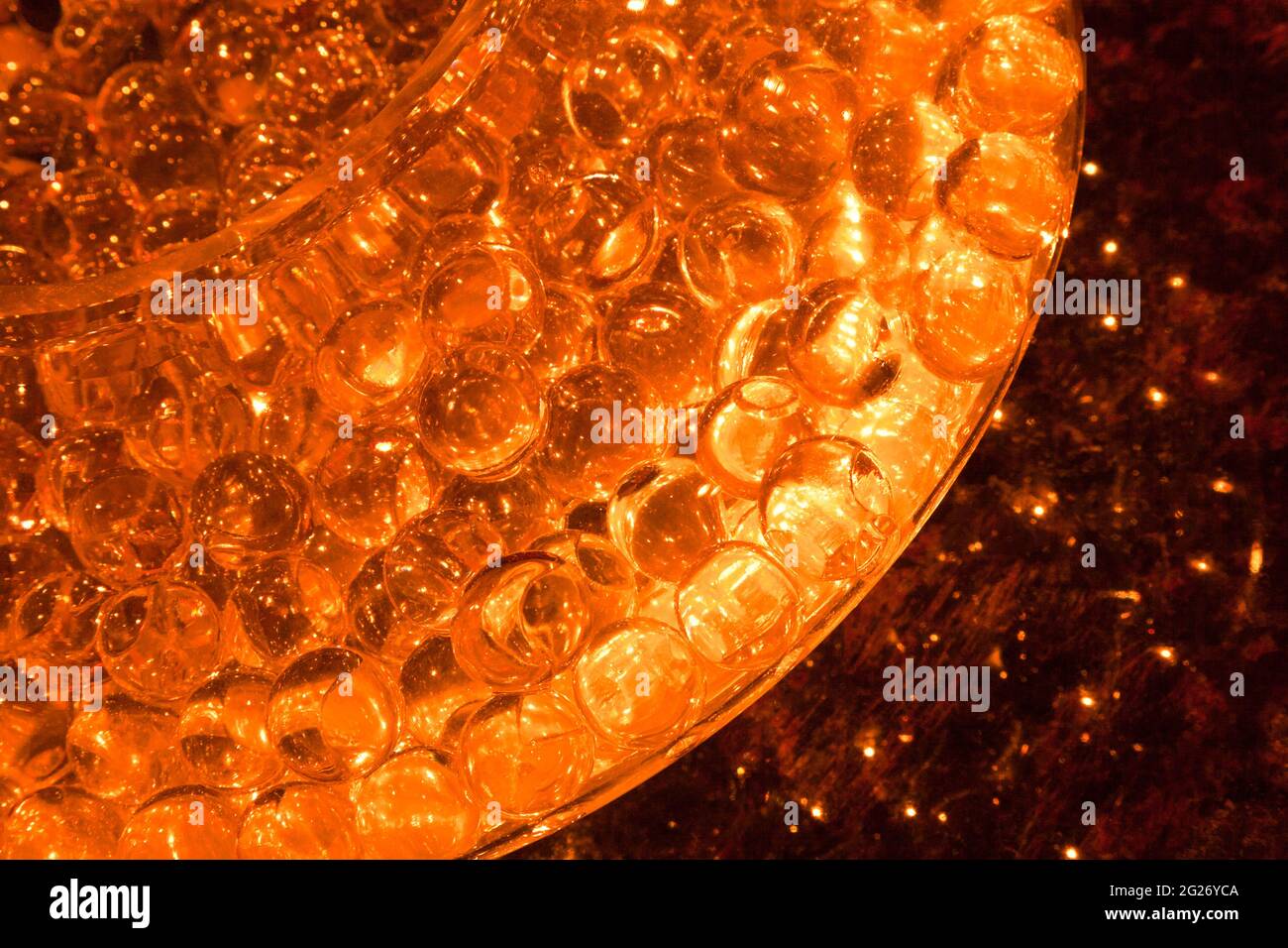 Abstract image of orange glass balls in a glass dish sitting on a