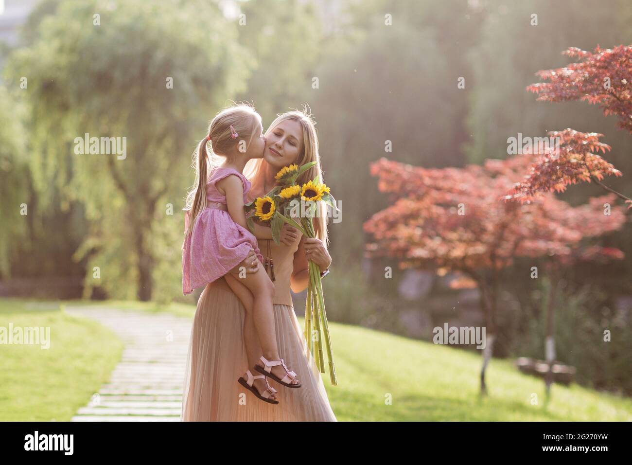 Portrait of beautiful woman and girl with sunflowers Stock Photo - Alamy