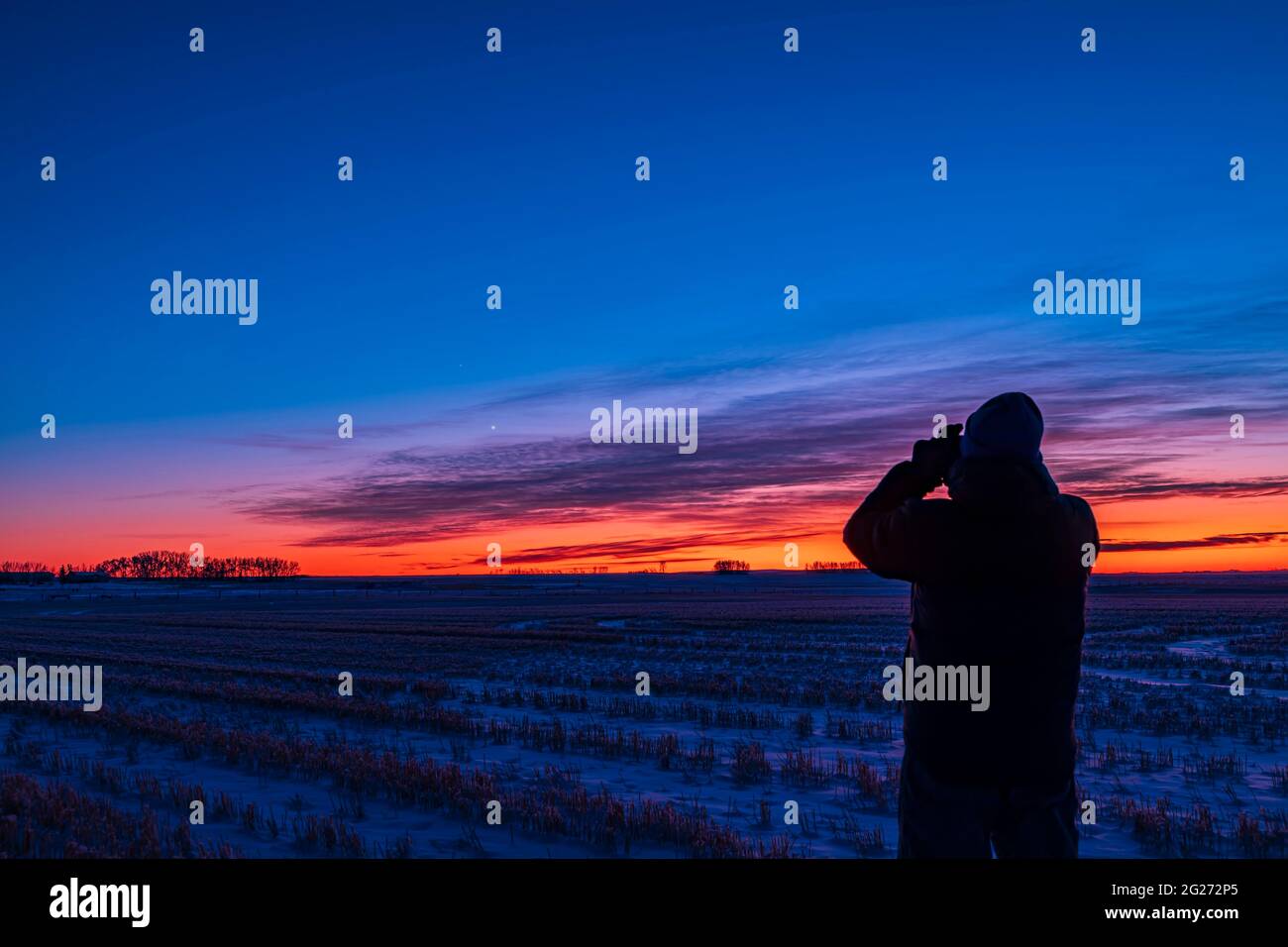 Astronomer observing the grouping of Venus and Saturn in the evening twilight. Stock Photo