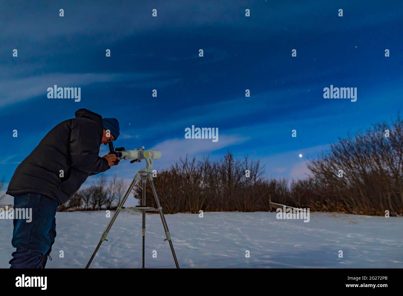 Astronomer observing Venus in clouds and in the moonlight. Stock Photo