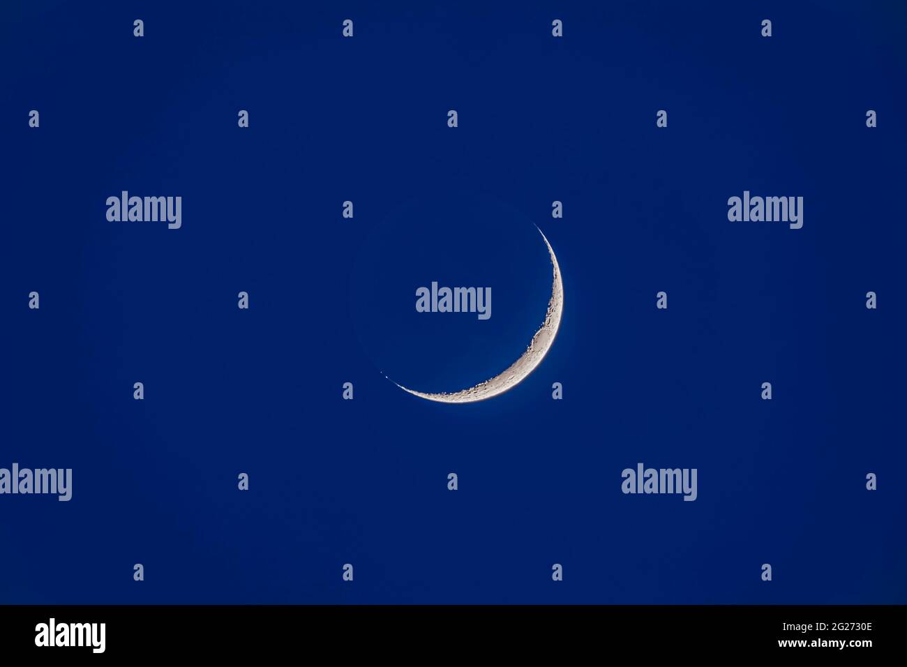 Waxing moon with earthshine in twilight. Stock Photo